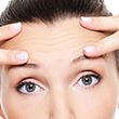 Female face with wrinkles on forehead - skincare treatment